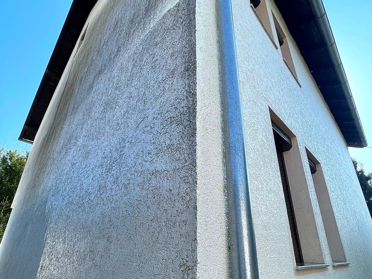 Fasadë e ndotur – njolla biologjike në suvatim, pamje nga poshtë lart